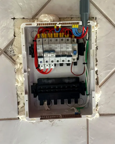 Quadro de distribuição novo embutido na parede de azulejo, com os disjuntores e os fios ligados