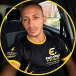 Eduardo, o eletricista, dentro do carro, de camisa preta com o logo dele