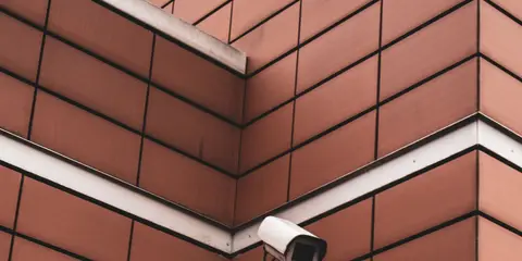 Câmera de segurança presa na quina de uma parede