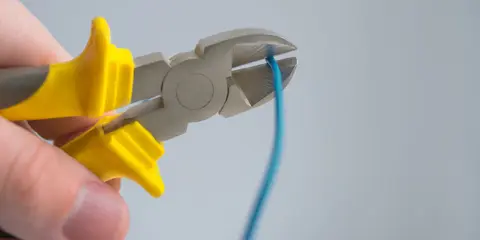 Alicate cortando um fio azul