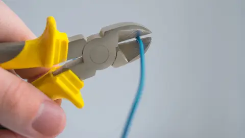 Alicate cortando um fio azul