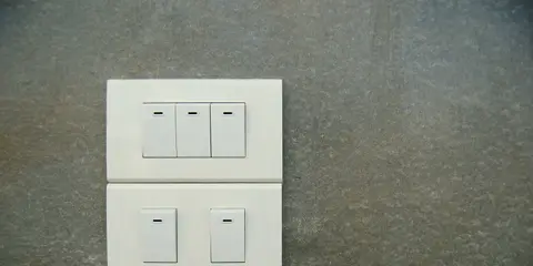 Interruptores brancos numa parede cinza